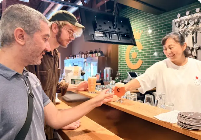 大阪のクラフトビール店を楽しむ旅行者