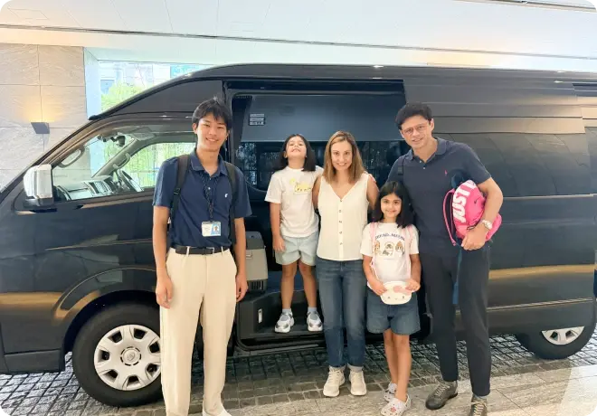 専用車を利用する旅行者家族とスタッフ